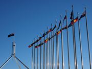 Australian Flags | Verified Journalism Press Australian flags fly outside Parliament House, representing issues of inequality and Indigenous rights.